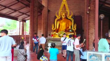 AYUTTHAYA, THAILAND - 5 Mayıs 2019 'da Budist dindarlar, Wat Yai Chai Mongkhon Tapınağı' nın Ubosot sundurmasında 5 Mayıs 'ta, Ayutthaya' da bulunan Buda 'nın altın imgesine dua ettiler.