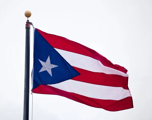 Drapeau de Porto Rico agitant contre le ciel bleu Images De Stock Libres De Droits