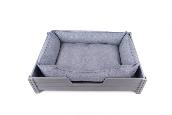 Cama azul para perro y gato en una base de madera. Isolar —  Fotos de Stock