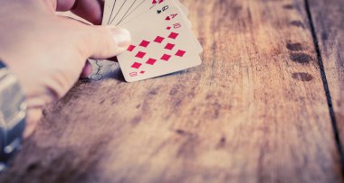 Tahta bir masada el ele iskambil oynuyoruz.