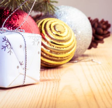 Noel ağacı dalları, koniler, süslemeler ve hediye kutusuyla 