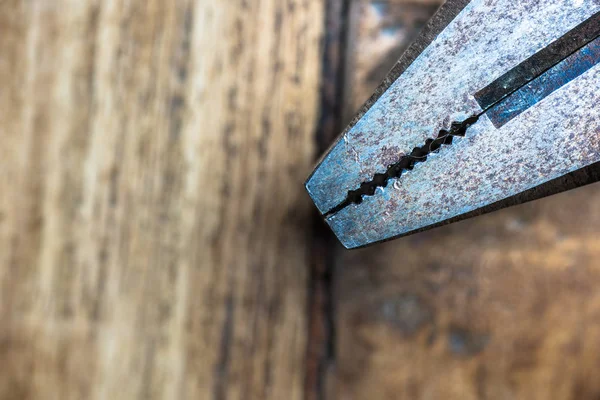 木製の作業台の上に古い金属さびペンチ。大工道具. — ストック写真