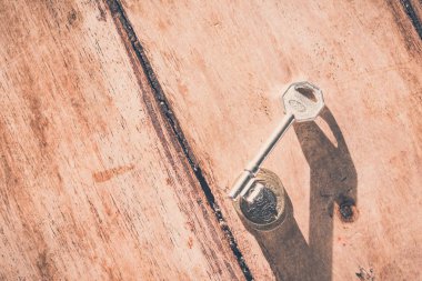 Antika ev anahtarı ve ahşap zeminde bozuk paralar.