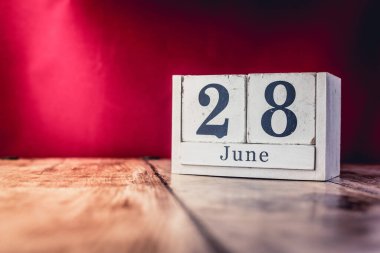 28 Haziran. Ayın 28 'i, iş yerindeki çalışma masasının takvimi, açık kırmızı arka planlı iş yeri. Yaz zamanı.