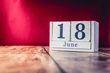18 Haziran. Ayın 18 'i, iş yerindeki çalışma masasının takvimi, canlı kırmızı arka planlı iş yeri. Yaz zamanı.