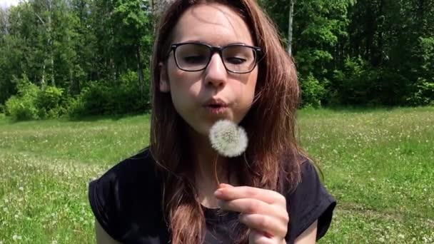 Ragazza soffia via il dente di leone — Video Stock