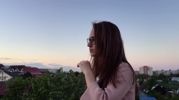 Девушка на крыше выпрямляет волосы — стоковое видео