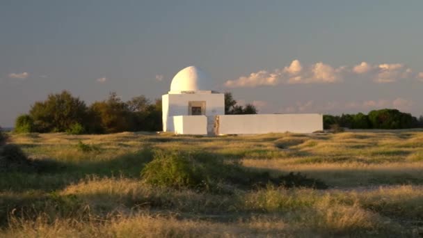 Arab tomb in the green field. White little house with a fence. Crypt — Stockvideo