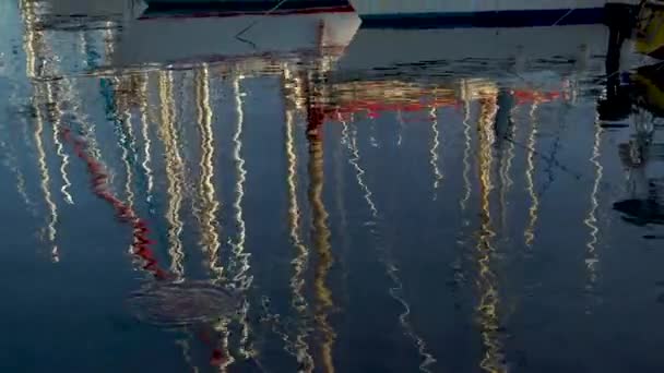 Masten van schepen worden weerspiegeld in het water. Moderne schepen zijn in de baai. Panorama van onder naar boven — Stockvideo