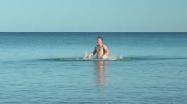 Denizde dolaşan genç bir adam. Akdeniz 'de mayo giymiş bir adam. Denizde dinleniyor. Suda eğleniyorum. Yüzme mevsimi