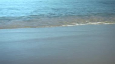 Akdeniz 'in kıyısında. Dalgalar dayanır. Turkuaz su. Kamera denize paralel hareket eder.