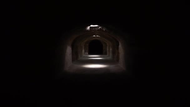Pass through a long and dark Roman basement. Basement under the amphitheater in El Jem, Tunis. Ancient roman building. The camera is approaching — Stockvideo
