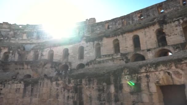 Antiguas ruinas romanas. Antiguo anfiteatro situado en El Jem, Túnez. Vista panorámica. Monumento histórico. El sol brilla en la cámara — Vídeos de Stock