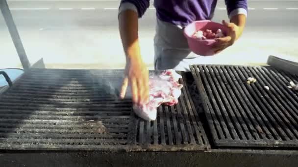 新鮮な赤肉を炭火で焼きます。男は生肉をグリルにかける。フライパンから煙 — ストック動画