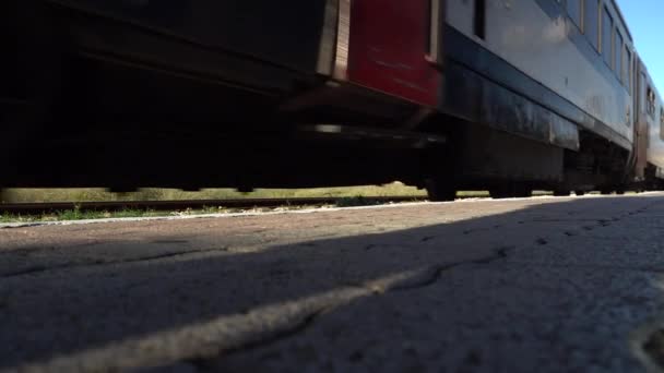 Correr la vista del tren desde abajo. Un tren se detiene hasta una plataforma que se ralentiza. — Vídeos de Stock