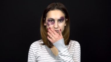 Genç bir kadın yüzündeki morluklara dokunur ve kameraya bakar. Genç bir ailede kavgalar. Aile içi şiddet. Siyah bir arkaplanda