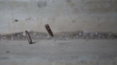 Silah sesi. Kol kalibresi 7.62 mm yavaşça yere düşüyor.