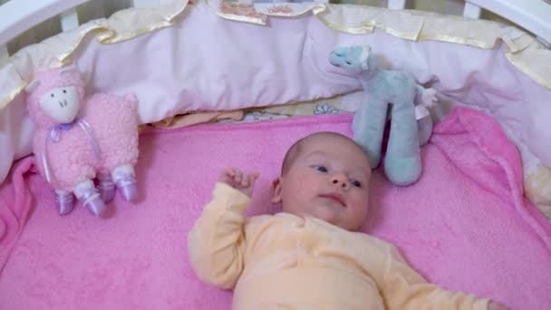 A baba a kiságyban van. A gyerek forgolódik és forgolódik. A kamera ráközelít — Stock videók