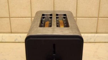 Ekmek kızartma makinesinden fırladı. Ekmek kızartılmış yakın plan. Kahvaltınız hazır. Mutfakta elektrikli alet var.