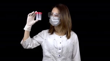 Genç kadın doktor sperm testlerini kontrol ediyor. Kadın test kavanozunu inceliyor, sonra baş parmağını aşağı gösteriyor. Sperm analizi negatif. Siyah bir arkaplanda.