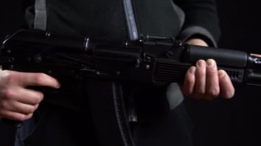 Elinde silahla siyah bir arka planda duran bir haydut. Manzarayı soldan sağa yakın tut..