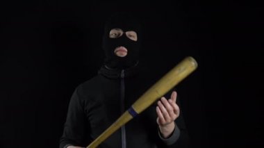 Kar maskeli bir adam elinde beyzbol sopasıyla duruyor. Siyah arka planda bir gangster beyzbol sopası tutuyor..