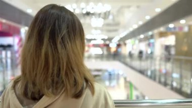 Young woman in a medical mask in a shopping center. A woman stands with her back, and then turns around and coughs. The masked woman protects herself from the epidemic of the Chinese virus 