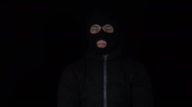 Kar maskeli bir adam bir tomar avroyu elinde tutuyor. Para içinde yüzen haydutlar. Siyah bir arkaplanda.