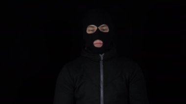 Kar maskeli bir adam bir tomar avroyla ayakta duruyor. Haydut parayı karıştırıyor ve seviniyor. Siyah bir arkaplanda.