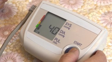 A man uses a device to measure heart pressure. A man pressed measure pressure using a tonometer close-up.