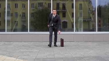 A young businessman in a suit is dancing. Modern youth flex. Background mirror business center. Slow motion