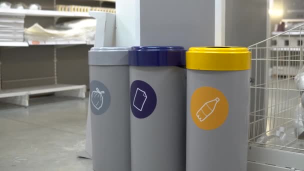 A young woman throws a plastic bottle into the trash. Special containers for sorting garbage. Container for plastic. — Stockvideo