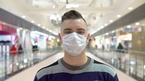 Alışveriş merkezinde maske takan genç bir adam. Maskeli adam kendini Çin virüsü salgınından koruyor "2019-NKoV" — Stok fotoğraf
