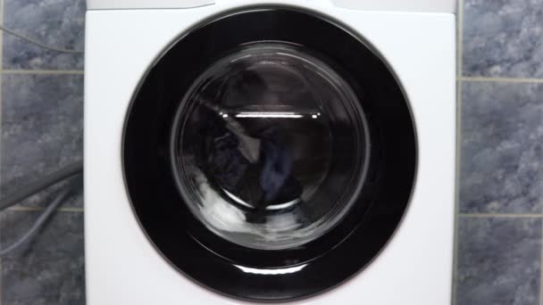 Tvättmaskinen fungerar. En tvättmaskin snurrar en trumma fylld med kläder. — Stockvideo