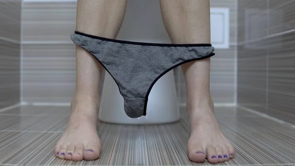 Mujer disparó bragas de tanga gris sentado en el inodoro. Chica con las piernas afeitadas en el inodoro — Foto de Stock