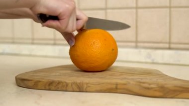 Kadın portakalı ikiye böler. Kadınların eli yakındır.