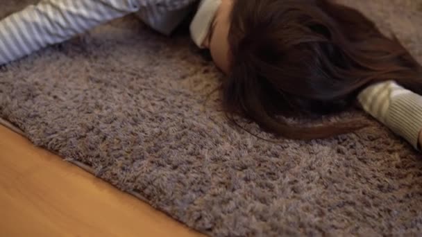 Une jeune femme est couchée sur le sol morte. Une femme dans un masque médical repose sur le sol de l'inconscience gros plan . — Video