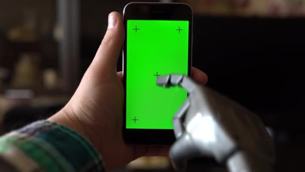 Cyborg använder telefonen. Grå mekanisk hand skriver på smartphone med grön skärm. Kromnyckel. — Stockvideo