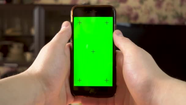 De man gebruikt de telefoon. Hand maakt een vingerklik op de smartphone met een groen scherm. Chromatoetsen. — Stockvideo