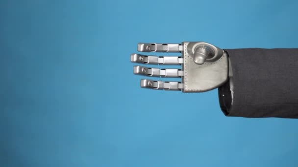 Una giovane donna scuote il braccio meccanico grigio di un cyborg. Stretta di mano di due uomini d'affari. Primo piano mani su sfondo blu . — Video Stock