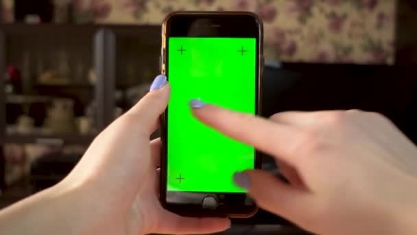 De vrouw gebruikt de telefoon. Hand maakt swipe naar links op de smartphone met groen scherm. Chromatoetsen. — Stockvideo
