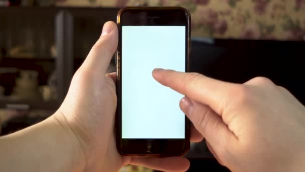 Он пользуется телефоном. Рука делает двойное нажатие пальцем на смартфон с белым экраном. Шаблон . — стоковое видео