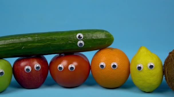 Fruta com olhos de perto. Foto de família de frutas e legumes em um fundo azul. A câmara afasta-se . — Vídeo de Stock