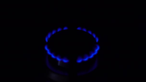 Palnik gazowy włącza się w ciemności. Kuchenka pracuje w domowym gazie. Płomień jest niebieski.. — Wideo stockowe