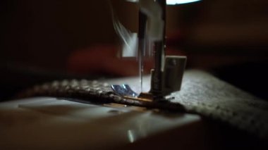 Dikiş makinesinde giysileri yakın plan dikerim. Terzi kumaş dikiyor..