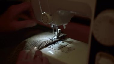 Dikiş makinesinde giysileri yakın plan dikerim. Terzi kumaş dikiyor..
