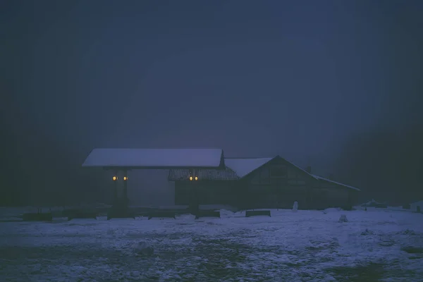 Spaventoso vecchio distributore di benzina e casa di notte — Foto Stock