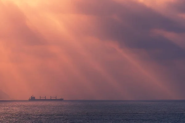 Rayons du soleil sur l'océan avec navire cargo — Photo