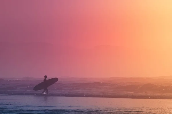 Серфер на заході сонця з мрійливими кольорами — стокове фото