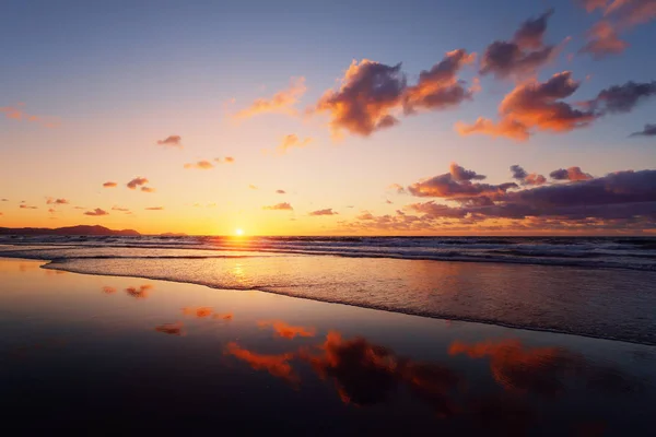 Coucher de soleil sur la plage avec reflets nuageux — Photo